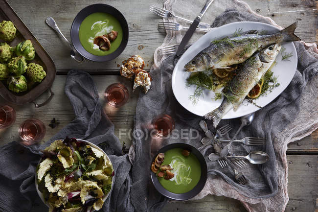 Stillleben mit Branzino-Fisch und Suppe — Stockfoto