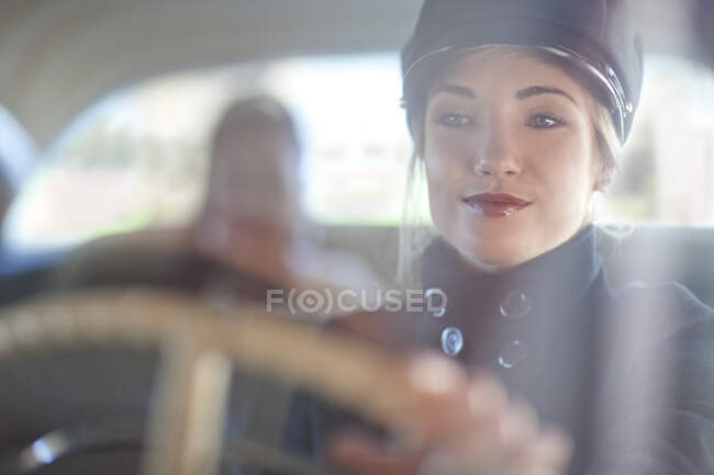 Mujer jugando al chofer en coche de época - foto de stock