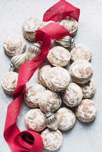 Biscotti di pan di zenzero con nastro rosso e decorazioni natalizie — Foto stock
