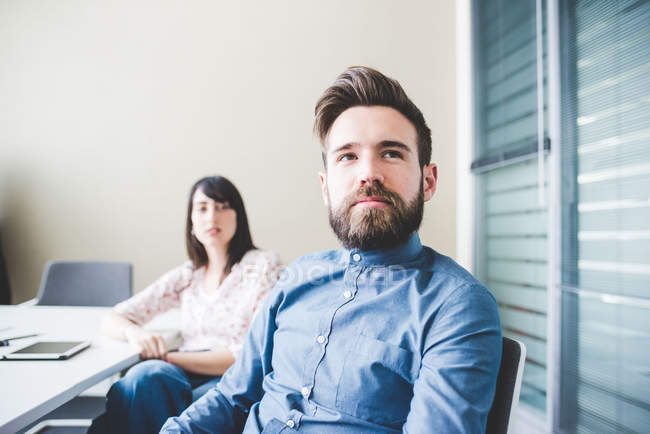 Two young designers listening in boardroom meeting — Stock Photo
