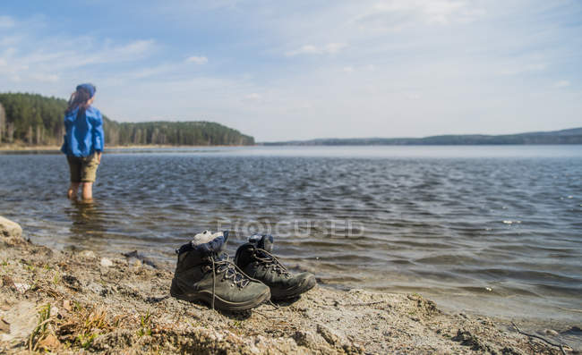 Mid adult female hiker taking a paddle in lake — Stock Photo