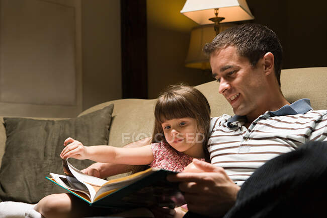 Père et fille lisant un livre — Photo de stock