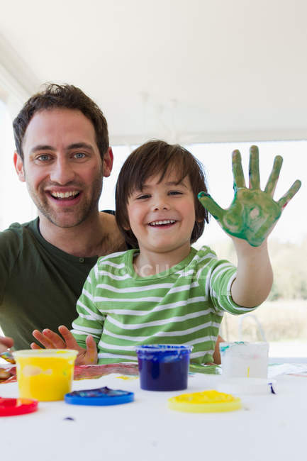 Отец и сын рисуют пальцами вместе — стоковое фото