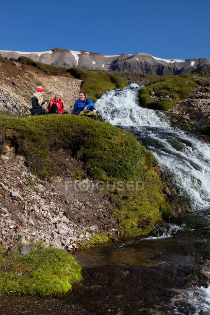 Caminhantes descansando por cachoeira, foco seletivo — Fotografia de Stock