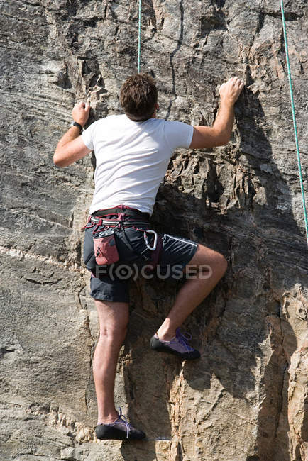 Rear view of male rock climber during daytime — Stock Photo