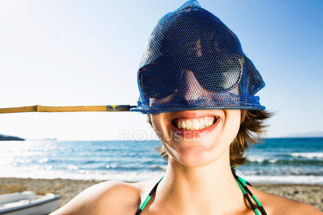 Woman holding fishing net on head — Stock Photo