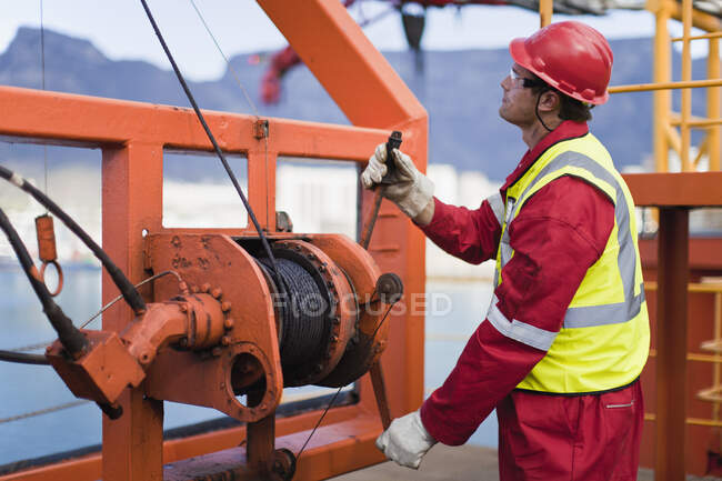 Cable de bobinado del trabajador en plataforma de aceite - foto de stock