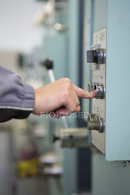Factory worker at control panel of machinery — Stock Photo