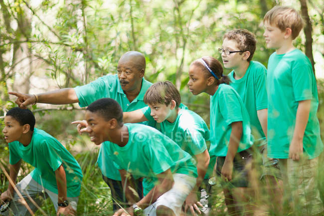 Schüler erkunden Wald mit Lehrer — Stockfoto