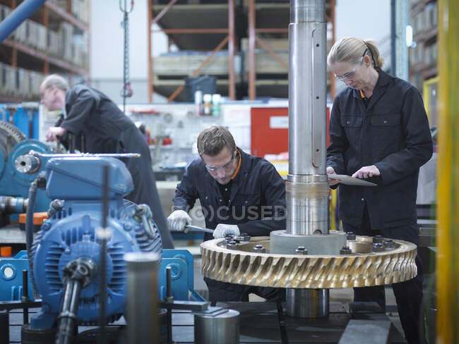Engineers assembling industrial gearbox in engineering factory — Stock Photo