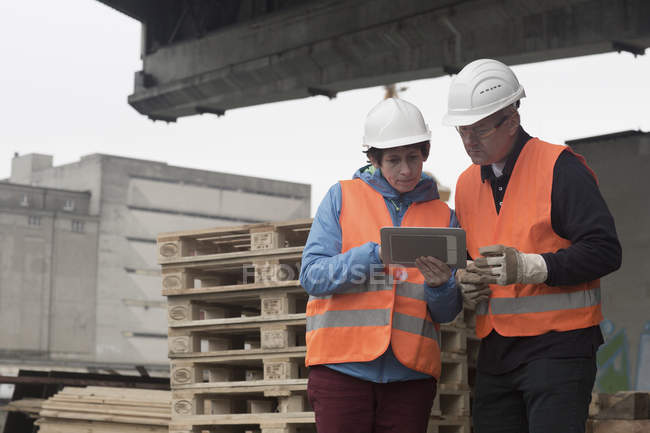 Trabajadores portuarios que utilizan tableta digital en puerto - foto de stock