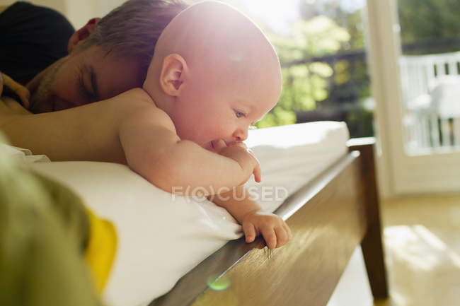 Père et bébé fille couchés sur le lit — Photo de stock