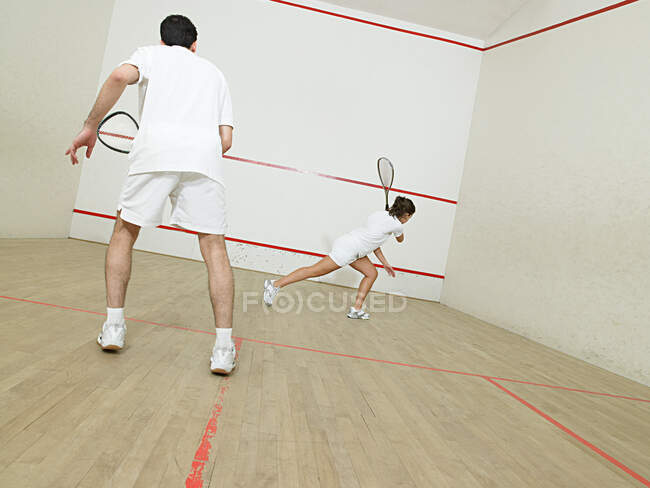 Hombre y mujer jugando squash - foto de stock