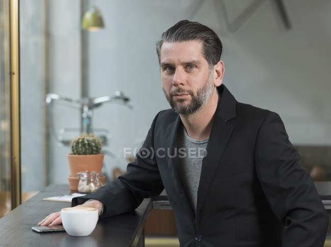 Portrait d'homme d'affaires cool assis au siège de la fenêtre du café — Photo de stock