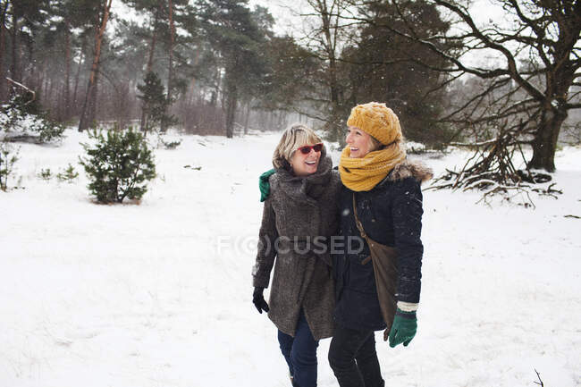 Mother and daughter walking in snow — Stock Photo