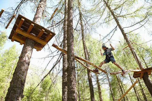 Persona che fa percorso ad ostacoli sulla cima degli alberi — Foto stock