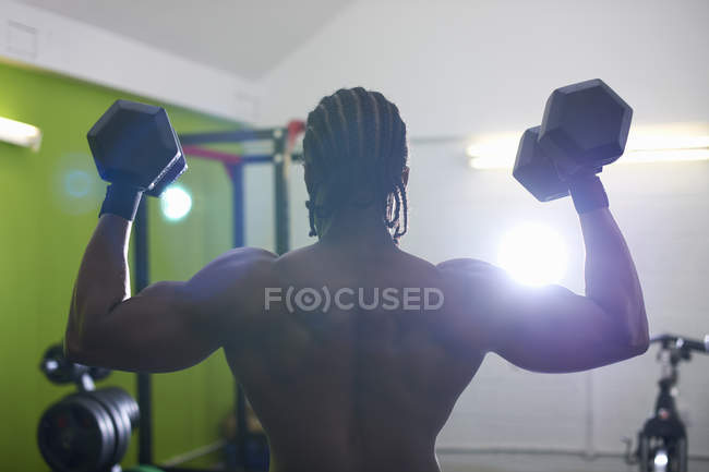 Bodybuilder lifting dumbbells in gym — Stock Photo