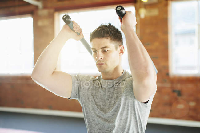 Homme soulevant des poids dans la salle de gym — Photo de stock