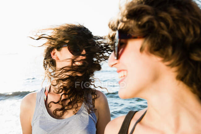 Donne ridenti in occhiali da sole sulla spiaggia — Foto stock