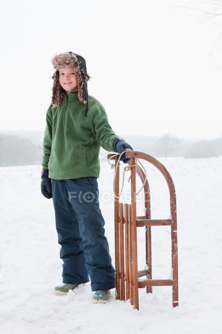 Хлопчик з санчатами на відкритому повітрі — стокове фото