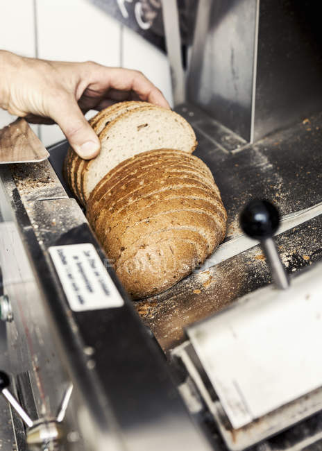 Homme cueillette à la main des tranches de pain frais — Photo de stock