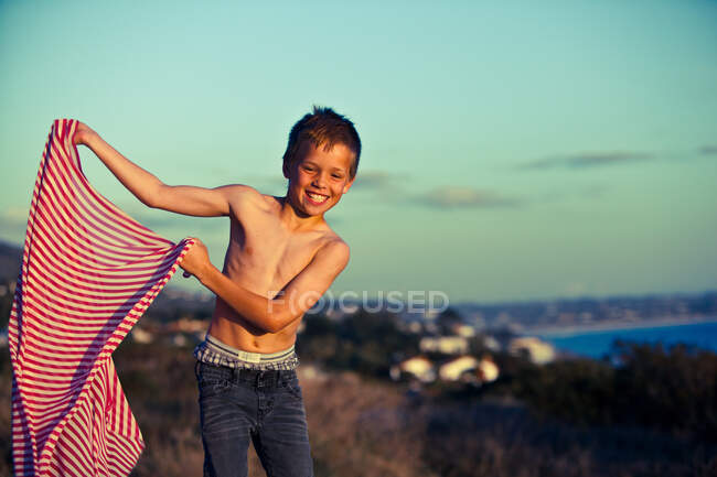 Boy holding striped fabric — Stock Photo