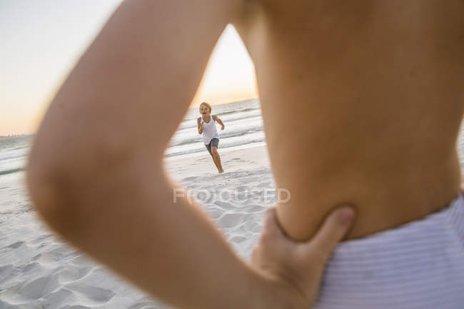 Vista attraverso ragazzi braccio di fratello correre sulla spiaggia — Foto stock