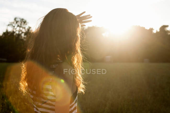 Woman shielding her eyes from sun — Stock Photo