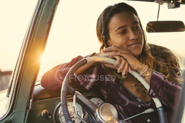 Young woman leaning against steering wheel in pickup truck at Newport Beach, California, USA — Stock Photo