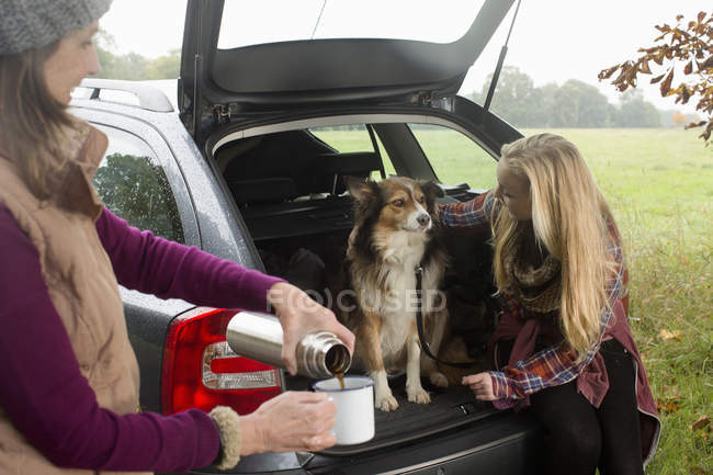 Senior woman and granddaughter with dog — Stock Photo