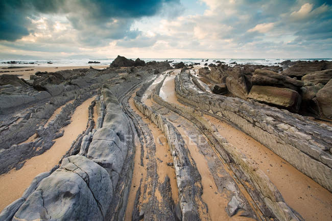 Curved stone formations on beach — Stock Photo