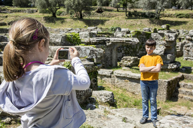 Menina fotografando seu irmão em ruínas, Florença, Itália — Fotografia de Stock