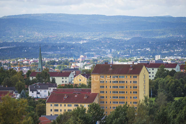 Vista aérea de edificios y hermosas colinas cubiertas de vegetación verde, Oslo, Noruega - foto de stock