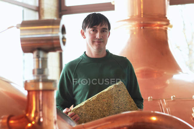 Brauerei-Mitarbeiter blickt bei Maschinenbedienung in Kamera — Stockfoto