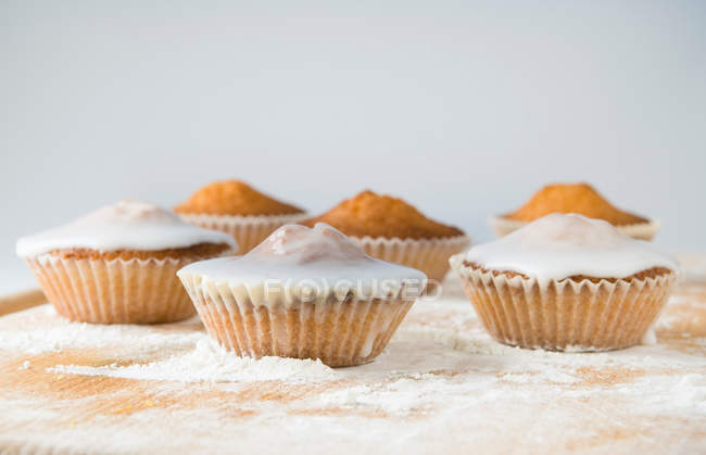 Iced cupcakes on cutting board — Stock Photo