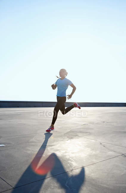 Mulher correndo no telhado — Fotografia de Stock