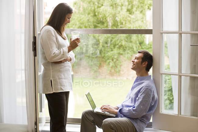 Mature couple talking at patio door — Stock Photo
