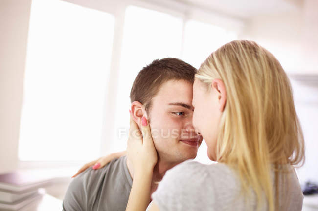 Подростковая пара обнимается в помещении — стоковое фото