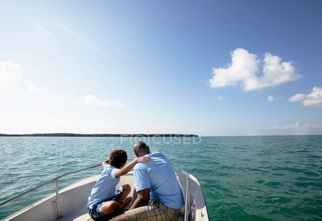 Father and son looking at view from motorboat — Stock Photo