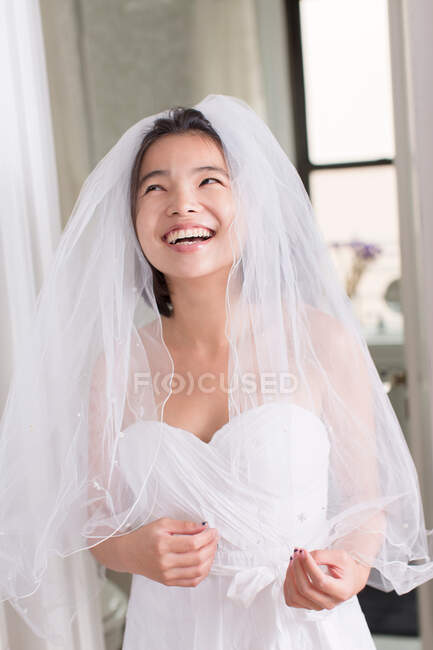 Jovem mulher vestindo vestido de noiva e rindo — Fotografia de Stock