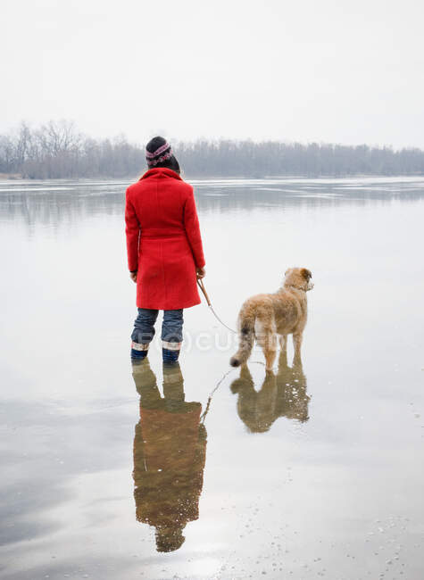 Young woman in river with dog — Stock Photo