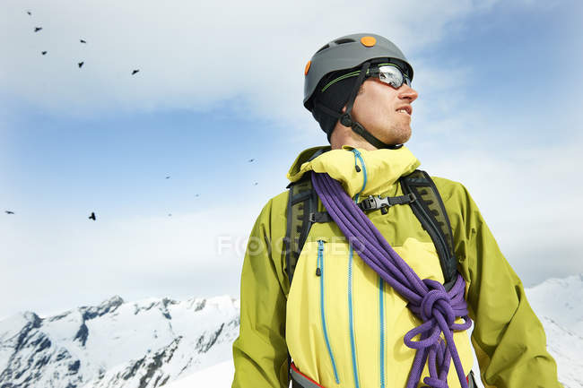 Portrait d'alpiniste sur une montagne enneigée regardant loin — Photo de stock