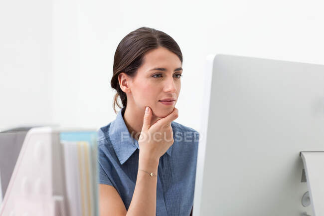 Mujer joven que trabaja en la computadora - foto de stock