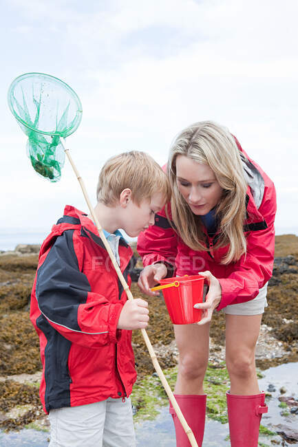 Mother and son looking in rock pool — Stock Photo