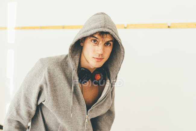 Man wearing hooded top and headphones looking at camera — Stock Photo