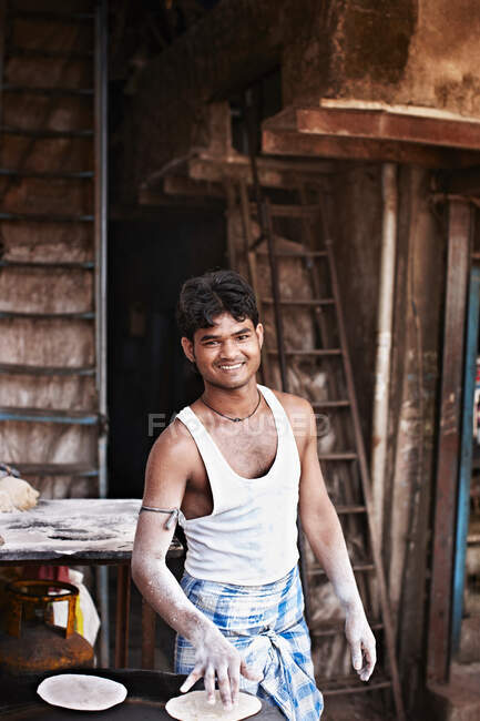 Lächelnder Mann grillt Fladenbrot im Freien — Stockfoto