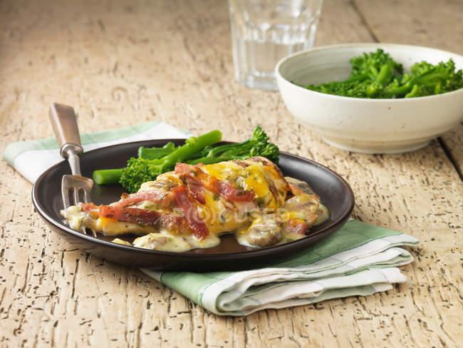 Pollo asado con queso y brócoli servido en el plato - foto de stock