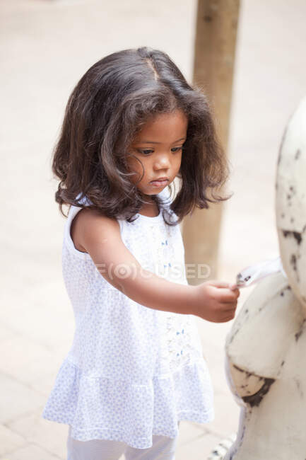 Девушка играет с игрушкой на открытом воздухе — стоковое фото