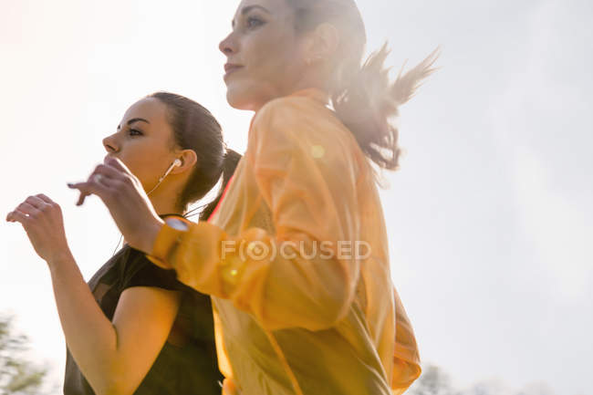 Two female friends exercising outdoors, running — Stock Photo