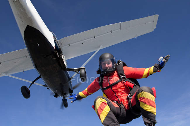 Женщина свободно прыгает с парашютом с самолета — стоковое фото